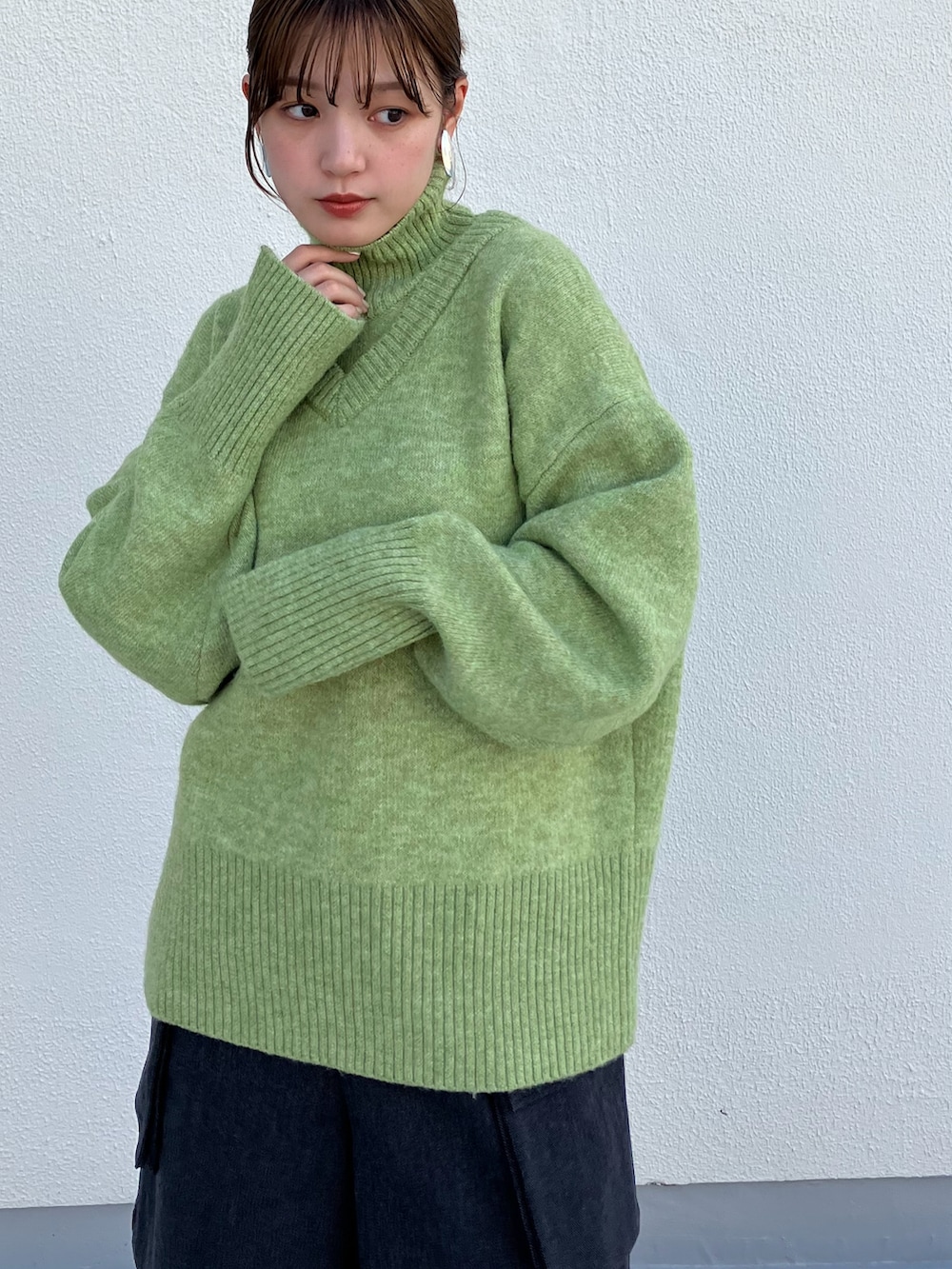 グリーン系のニット/セーター、グレー系のその他パンツ、ブラック系のブーツを着用したレディースの秋コーディネートの3枚目の写真