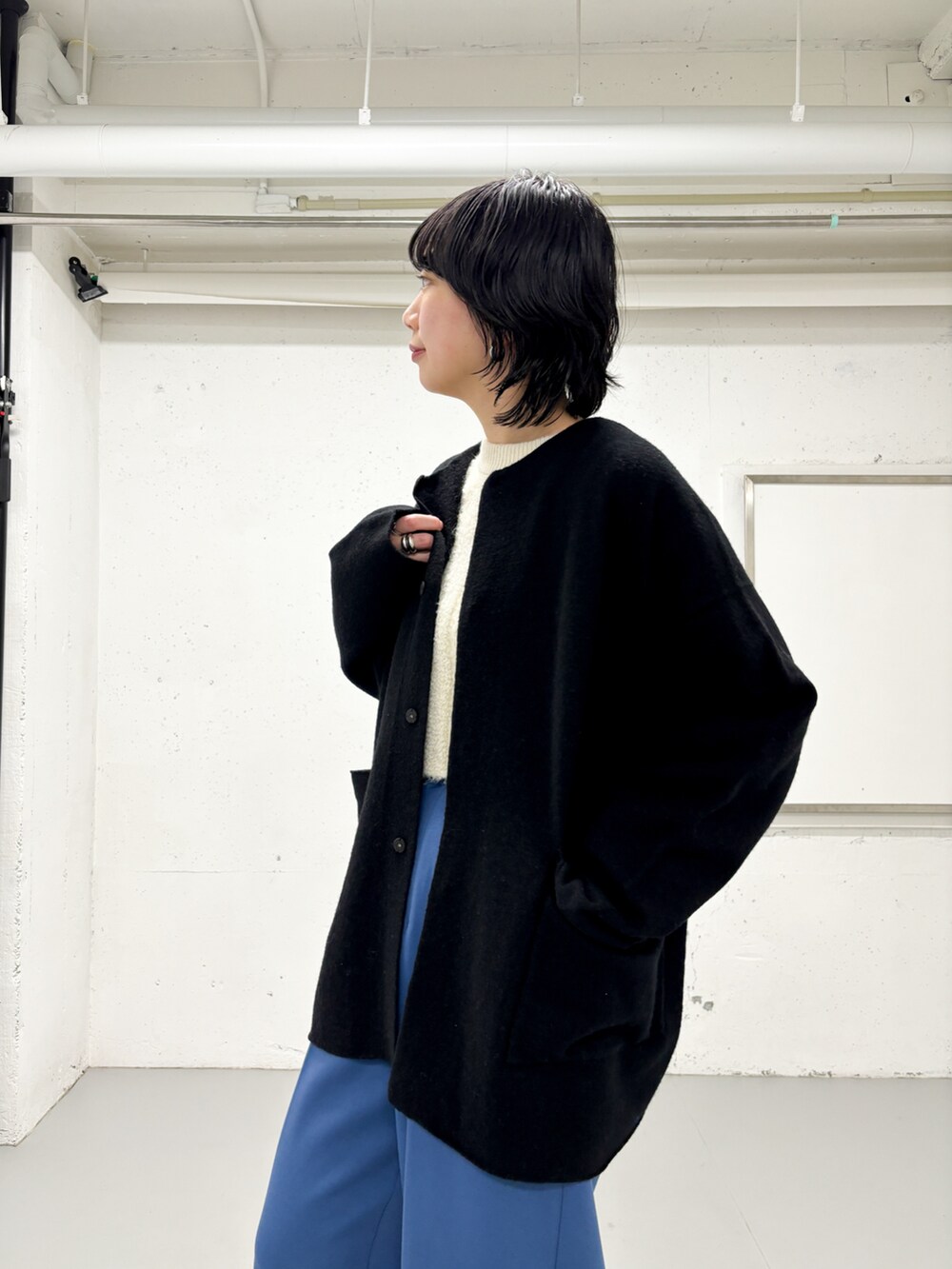 ブルー系のその他パンツ、ブラック系のノーカラージャケット、ホワイト系のニット/セーターを着用したレディースの冬コーディネートの3枚目の写真