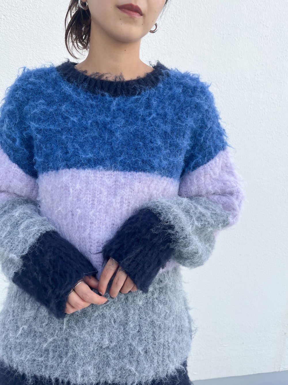 ピンク系のニット/セーター、ブルー系のデニムパンツ、ブラック系のブーツを着用したレディースの秋コーディネートの3枚目の写真