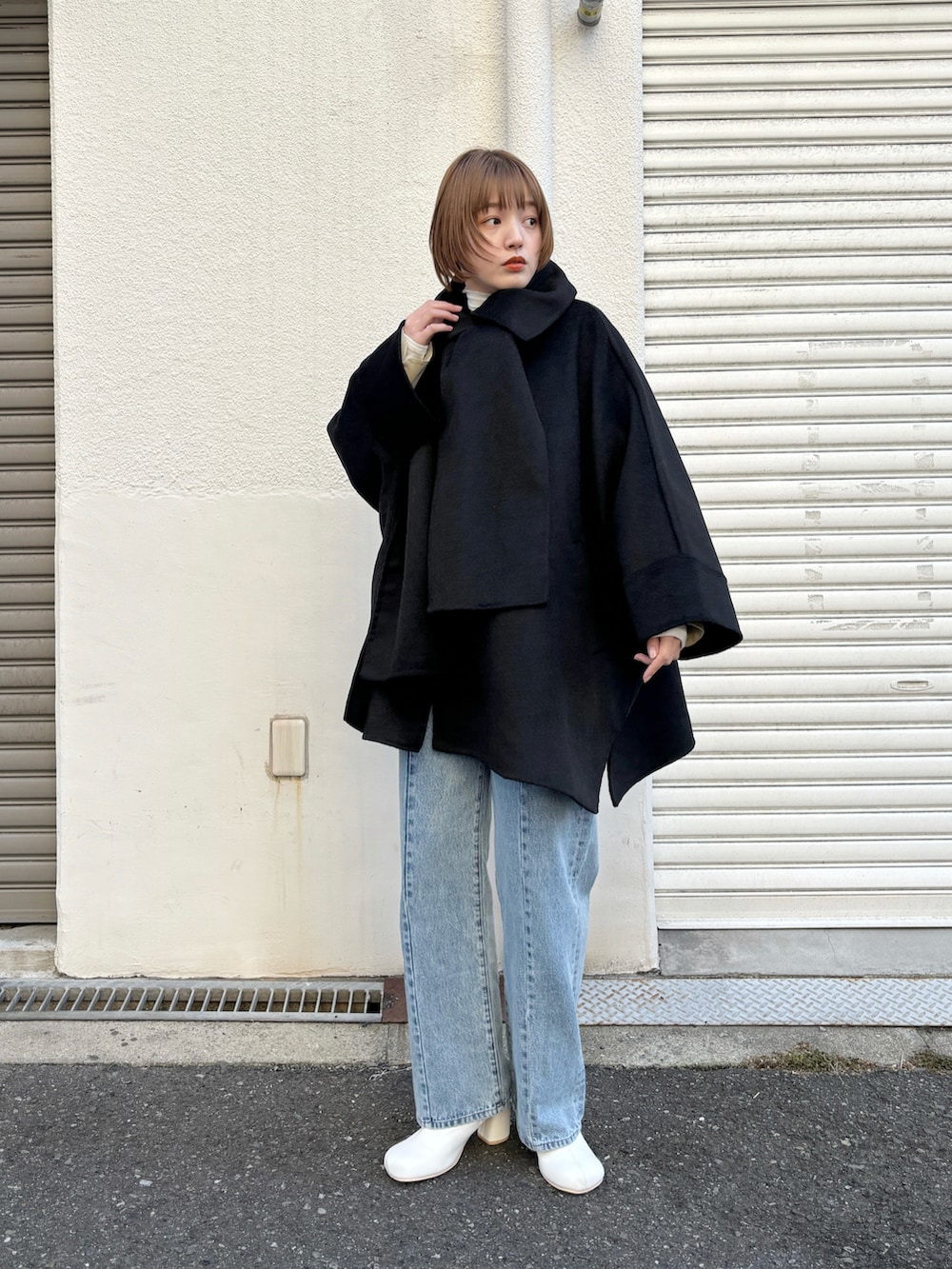 ブラック系のその他アウター、ブルー系のデニムパンツ、ホワイト系のブーツを着用したレディースの冬コーディネートの2枚目の写真