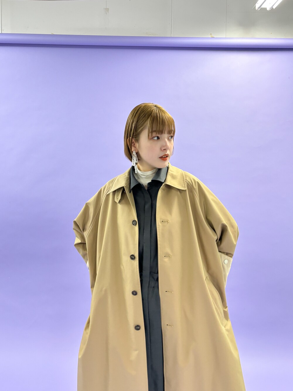 グレー系のステンカラーコートを着用したレディースの冬コーディネートの3枚目の写真