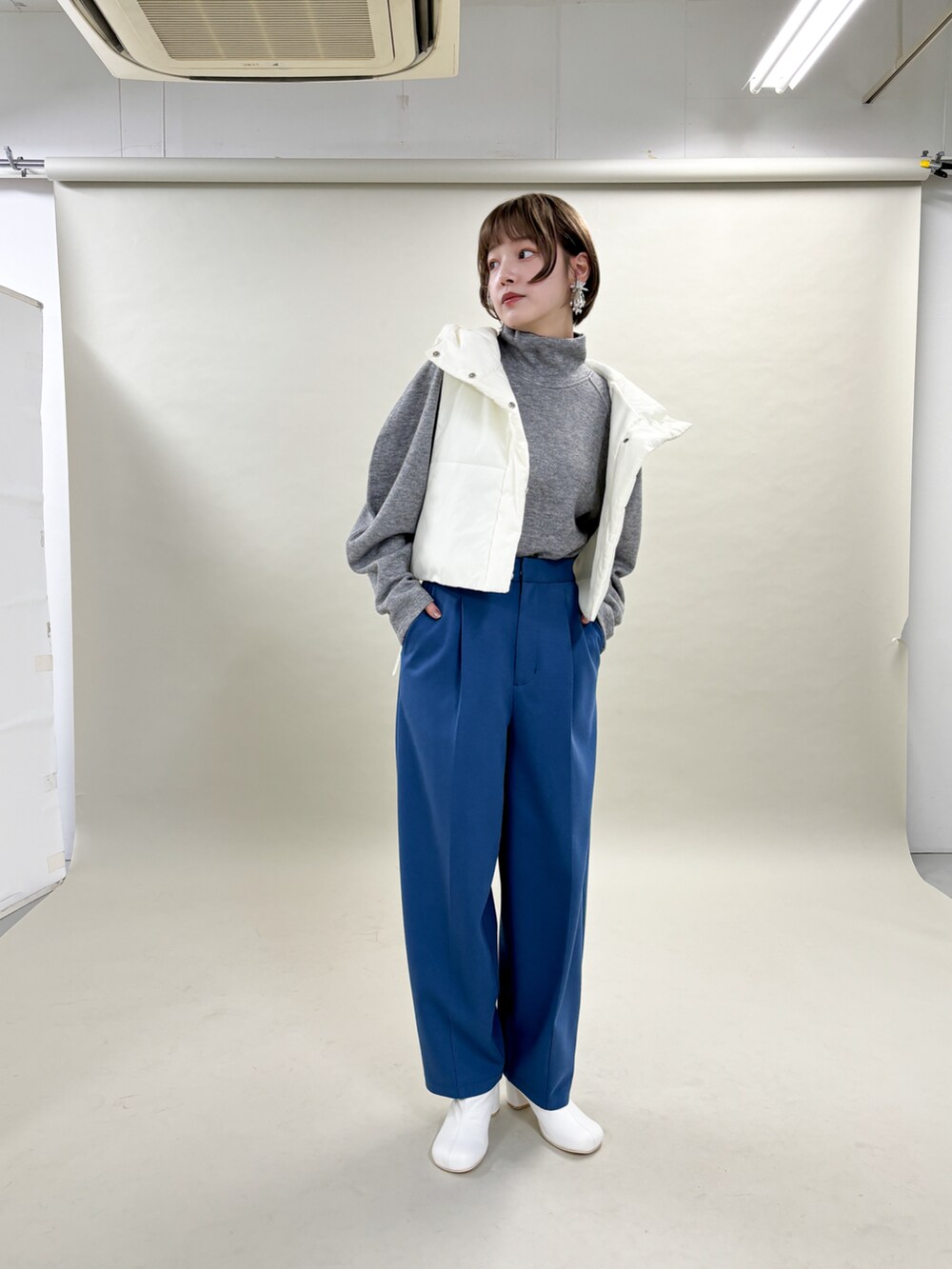 ホワイト系のダウンジャケット/コート、ブルー系のその他パンツ、ホワイト系のブーツを着用したレディースの冬コーディネートの3枚目の写真