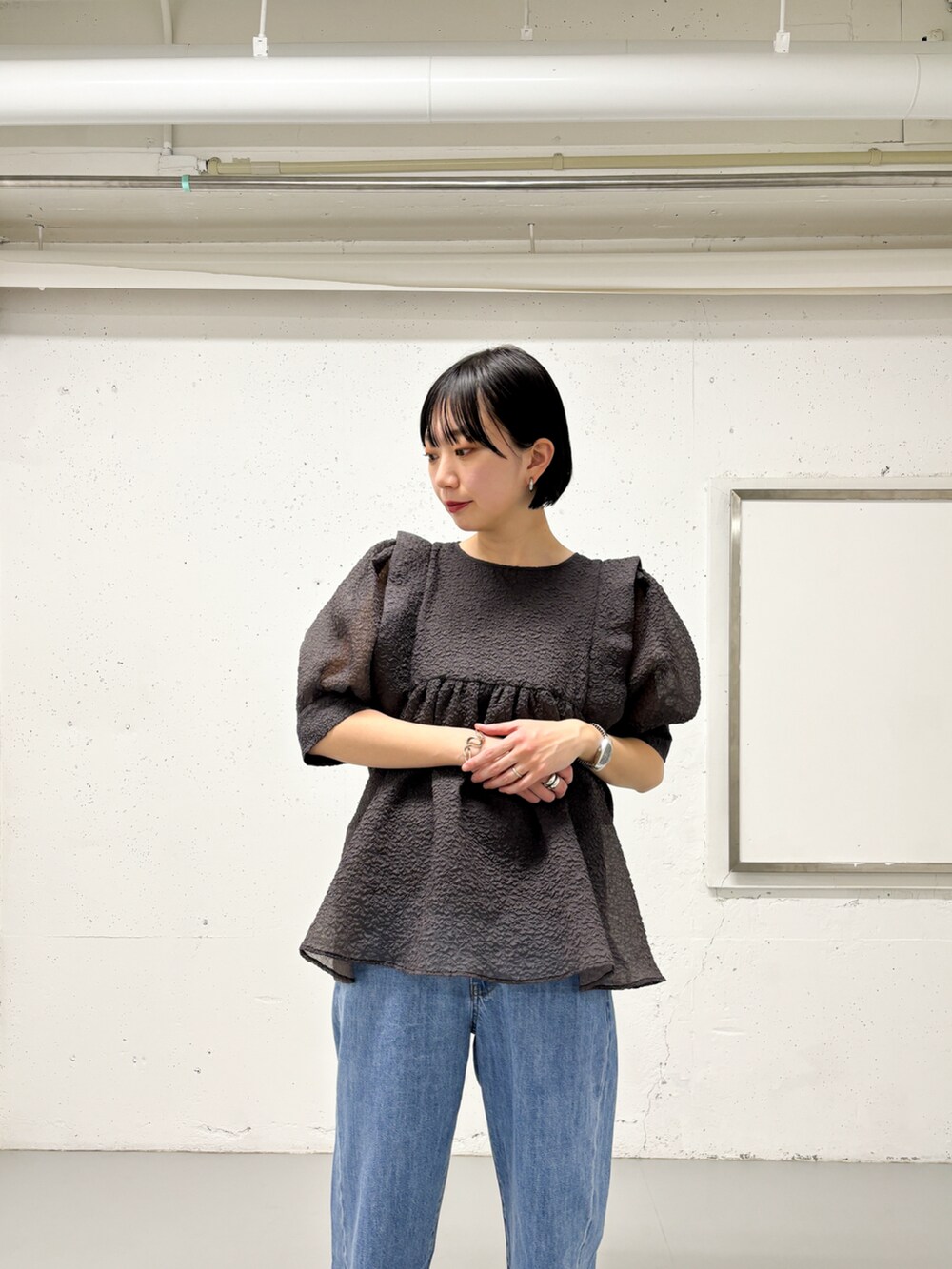 グレー系のシャツ/ブラウス、ブルー系のデニムパンツ、シルバー系のパンプスを着用したレディースの春コーディネートの4枚目の写真