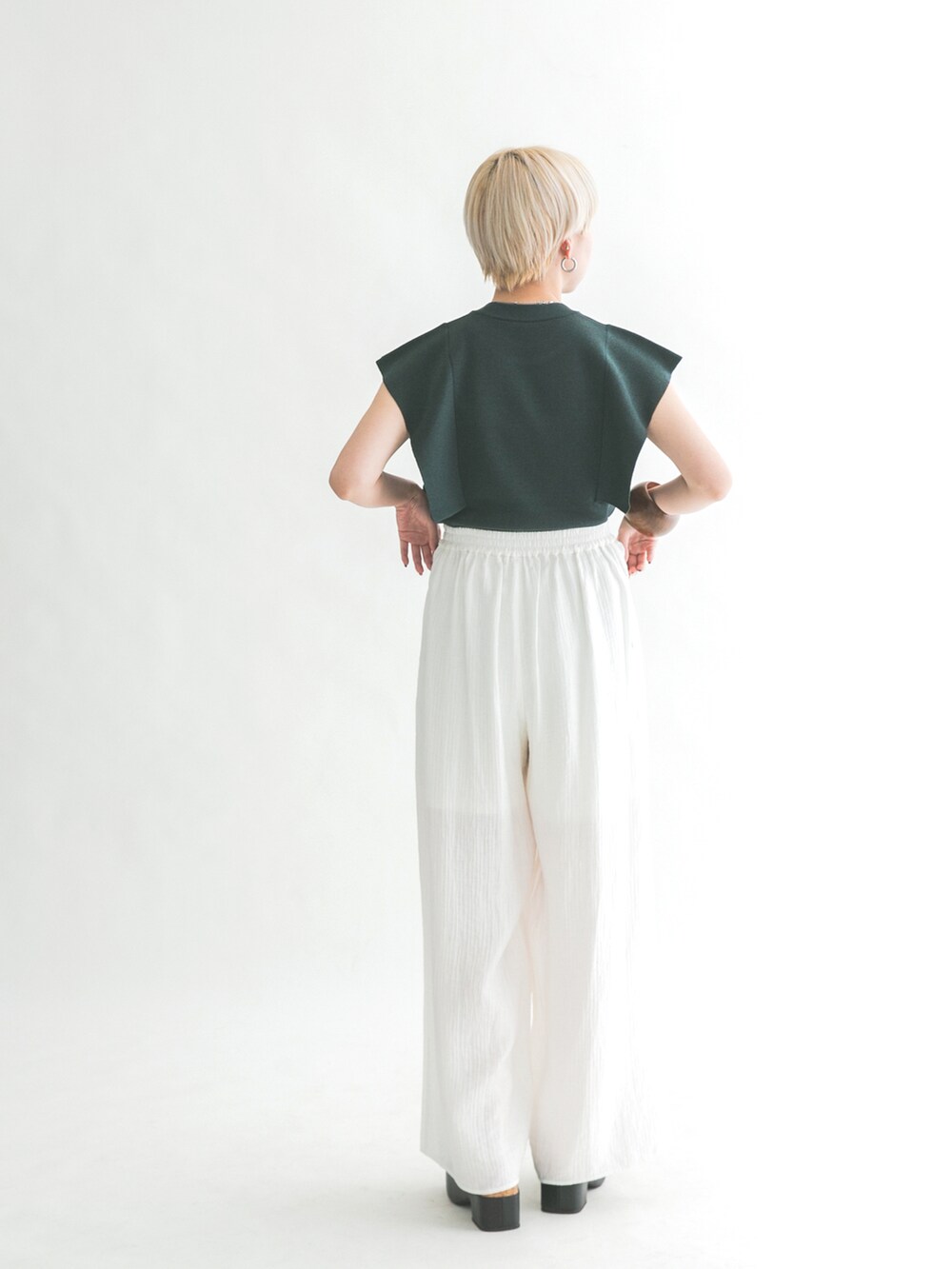 ブラック系のサンダル、グリーン系のニット/セーター、ホワイト系のその他パンツを着用したレディースの夏コーディネートの3枚目の写真