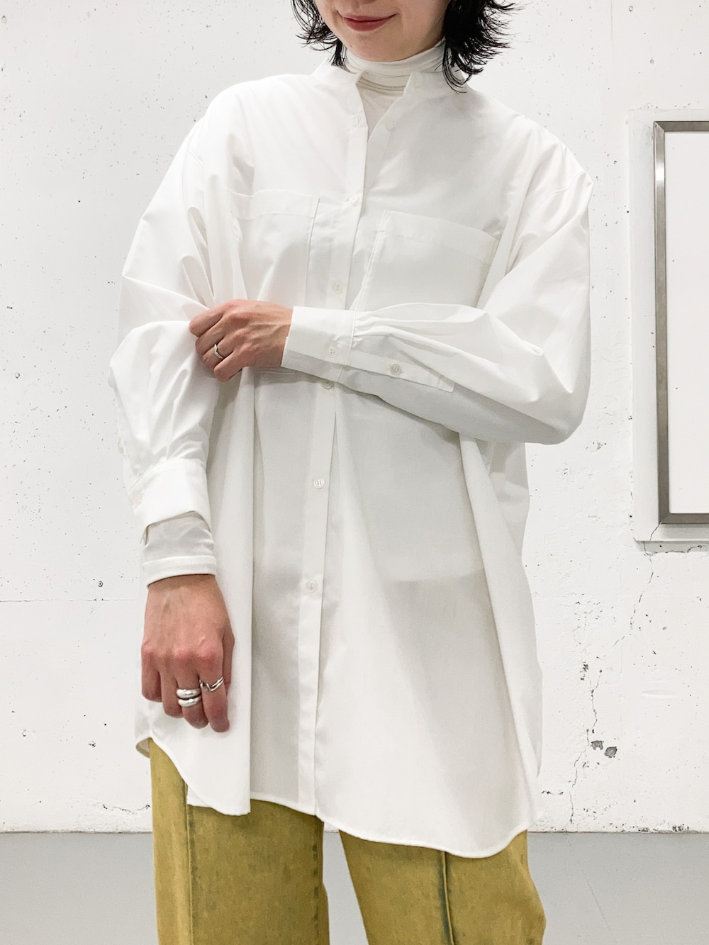 ホワイト系のシャツ/ブラウス、ホワイト系のTシャツ/カットソー、オレンジ系のデニムパンツを着用したレディースの秋コーディネートの2枚目の写真