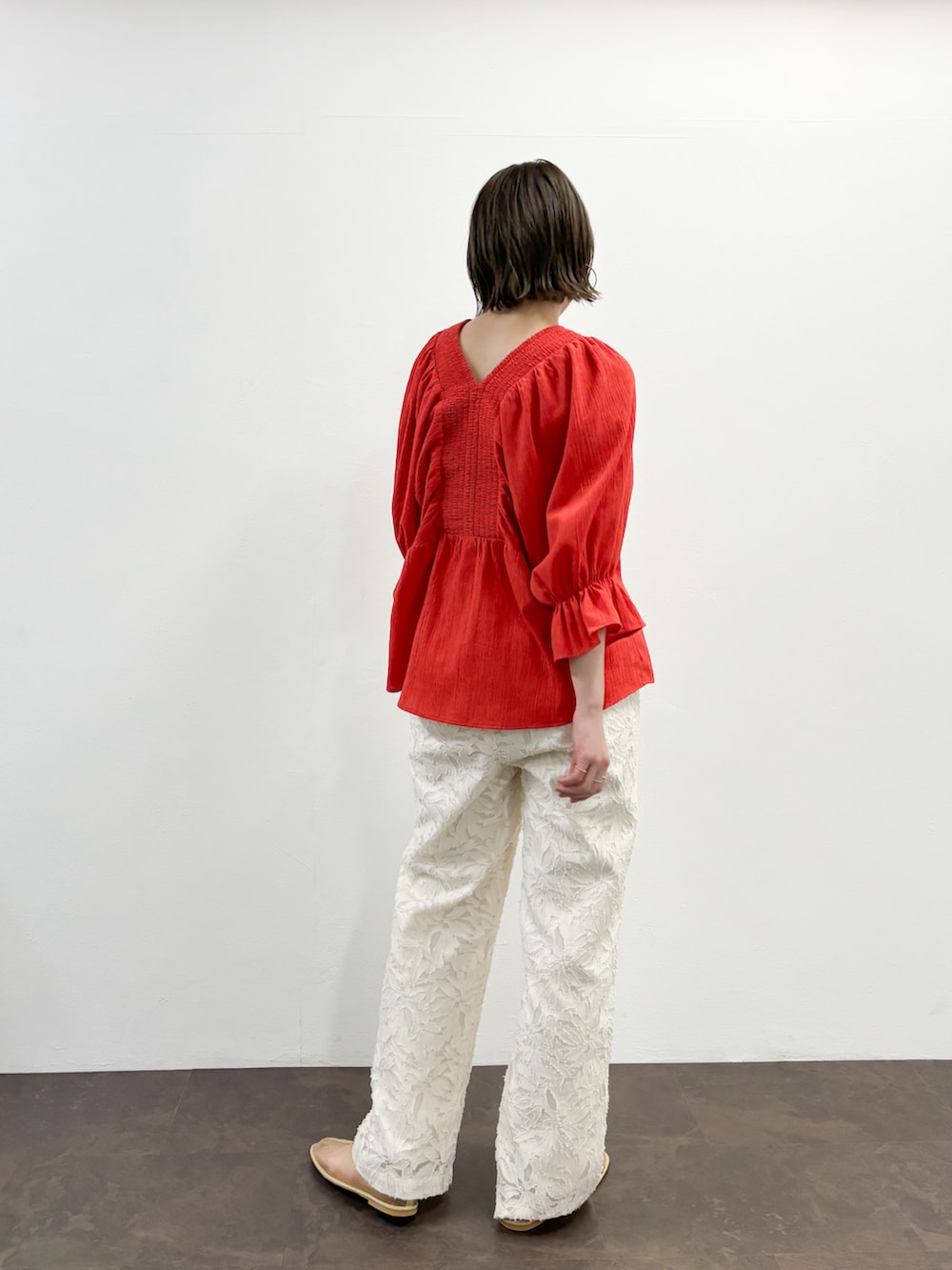 ホワイト系のその他パンツ、ベージュ系のその他シューズ、レッド系のシャツ/ブラウスを着用したレディースの春コーディネートの2枚目の写真