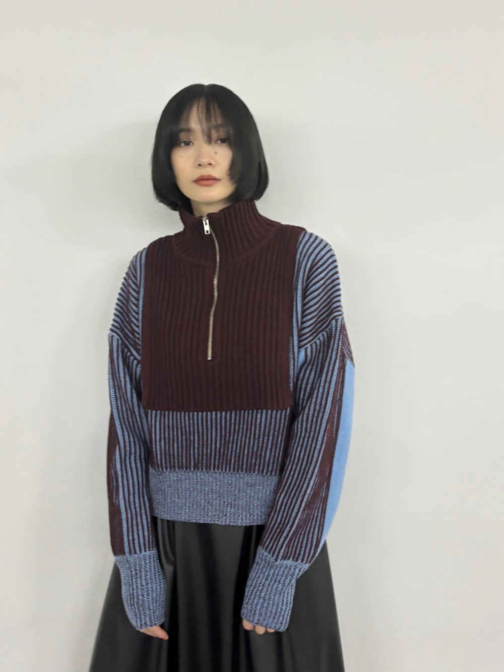 ブルー系のニット/セーター、ブラック系のブーツを着用したレディースの夏コーディネートの2枚目の写真