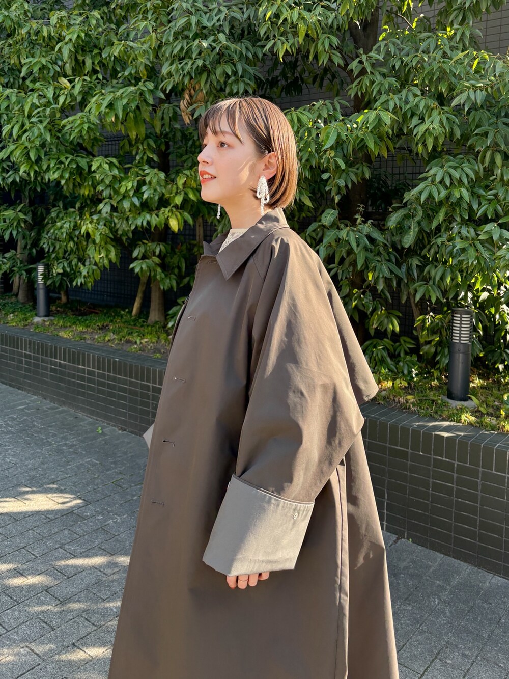 ブルー系のデニムパンツ、グレー系のステンカラーコートを着用したレディースの冬コーディネートの3枚目の写真