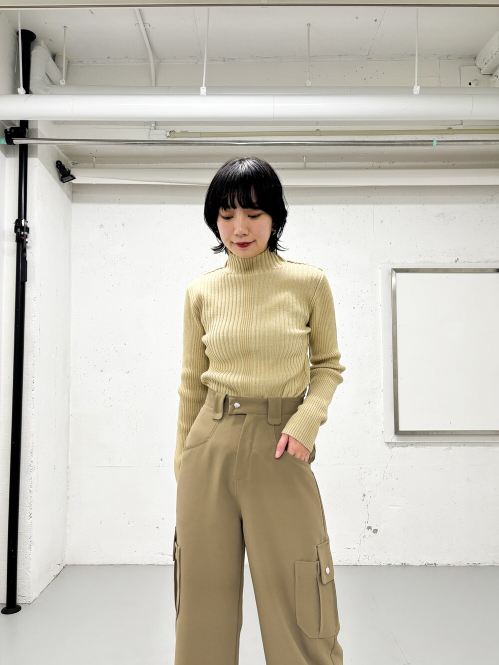 ベージュ系のニット/セーター、グリーン系のその他パンツ、オレンジ系のカーディガン/ボレロを着用したレディースの冬コーディネートの4枚目の写真