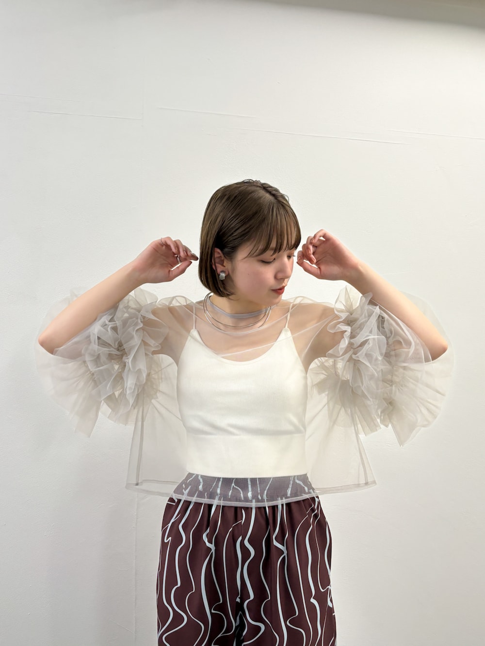 グレー系のシャツ/ブラウス、レッド系のその他パンツを着用したレディースの春コーディネートの2枚目の写真