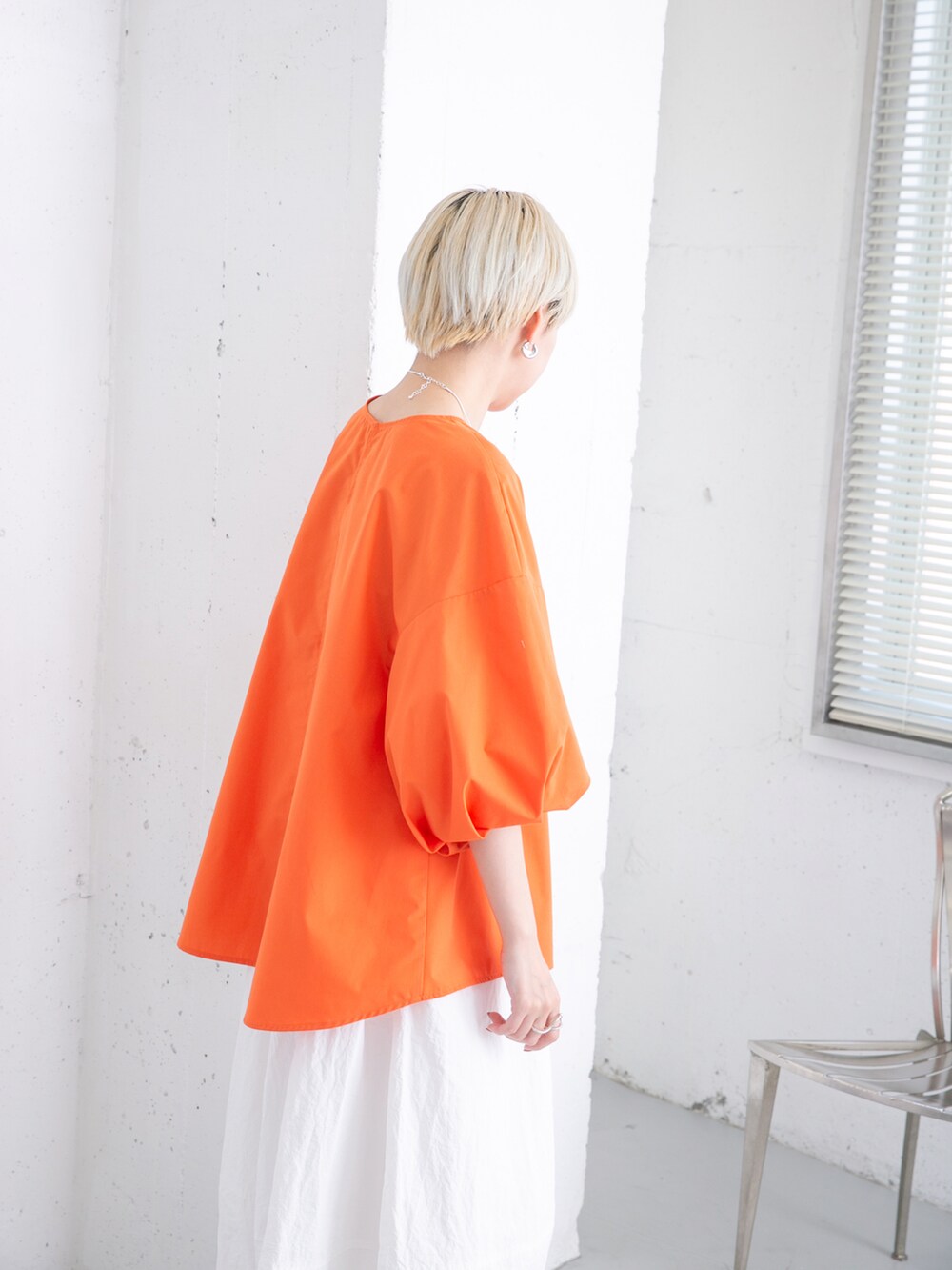 オレンジ系のシャツ/ブラウス、ホワイト系のスカートを着用したレディースの夏コーディネートの3枚目の写真