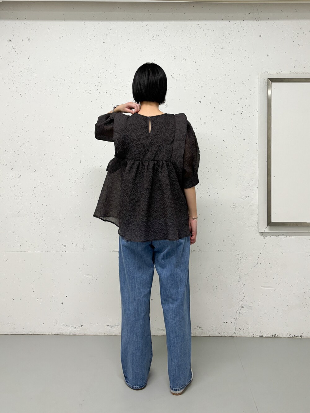 グレー系のシャツ/ブラウス、ブルー系のデニムパンツ、シルバー系のパンプスを着用したレディースの春コーディネートの3枚目の写真