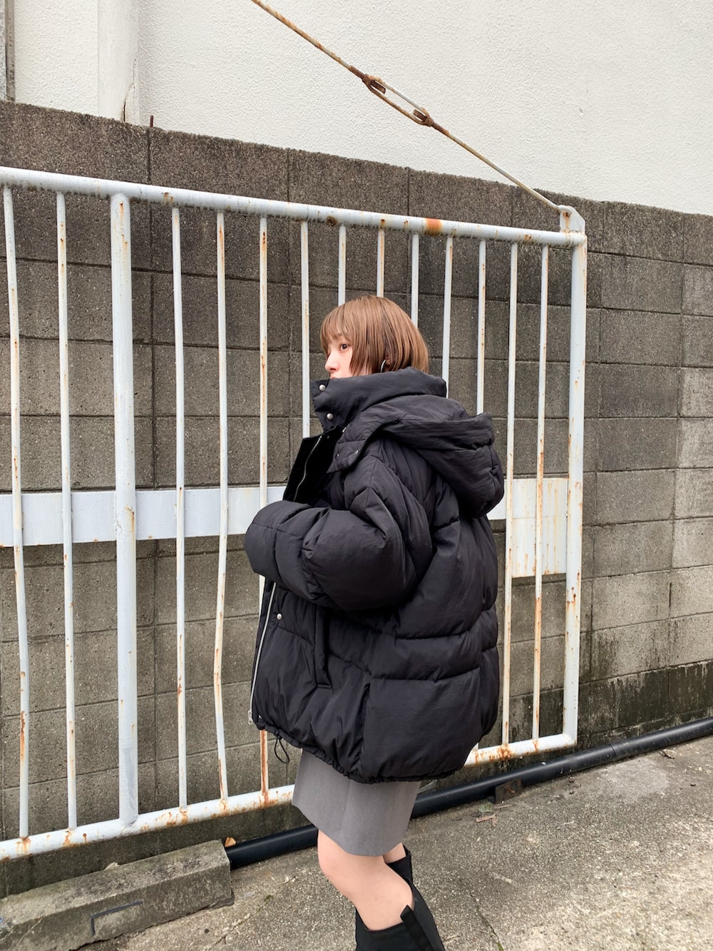 グレー系のニット/セーター、ブラック系のダウンジャケット/コート、グレー系のその他パンツを着用したレディースの冬コーディネートの3枚目の写真