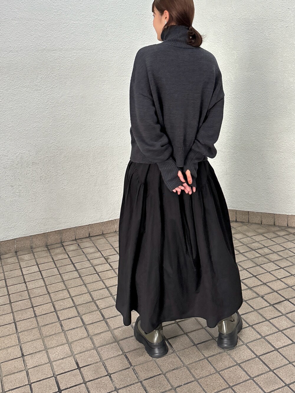 ブラック系のワンピース、グリーン系のブーツを着用したレディースの秋コーディネートの4枚目の写真