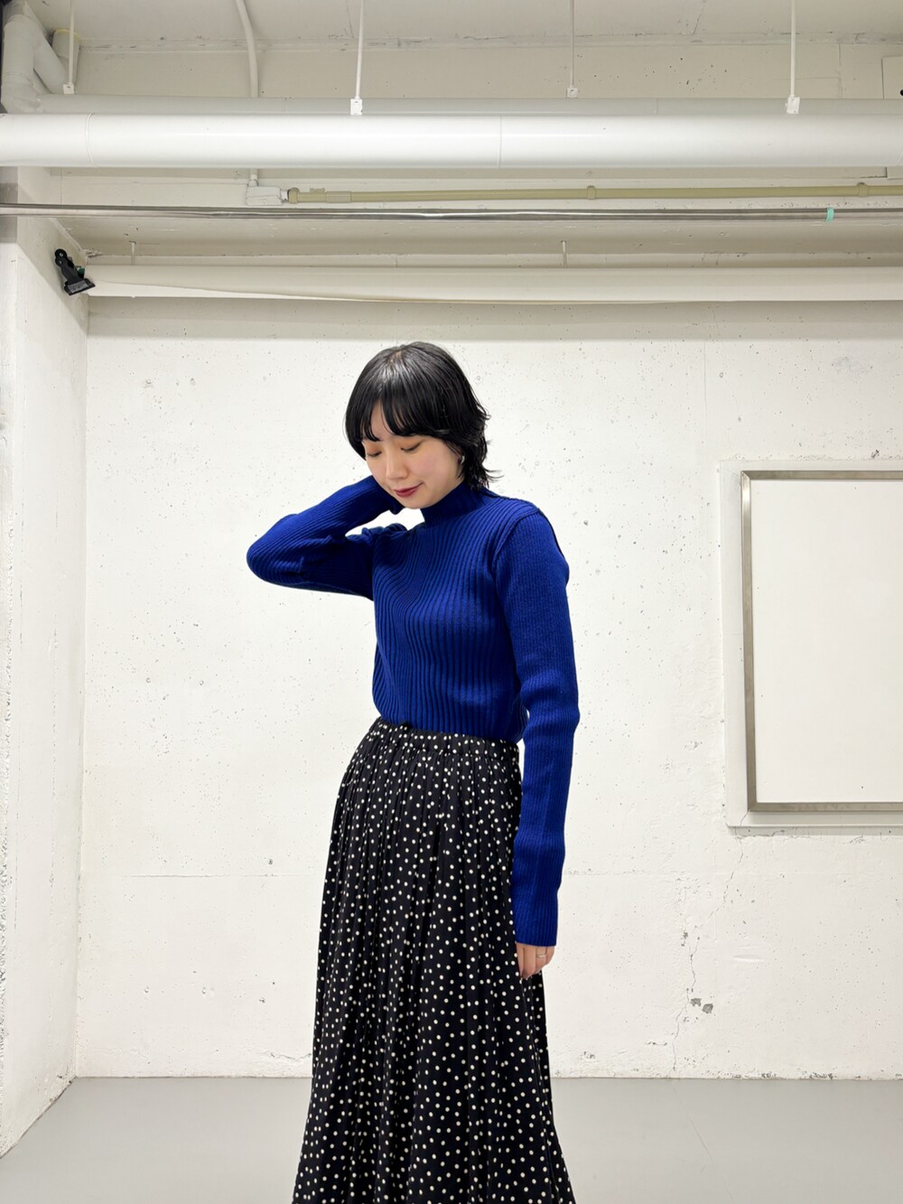 ブラック系のスカート、ブルー系のニット/セーター、ブラック系のブーツを着用したレディースの冬コーディネートの4枚目の写真