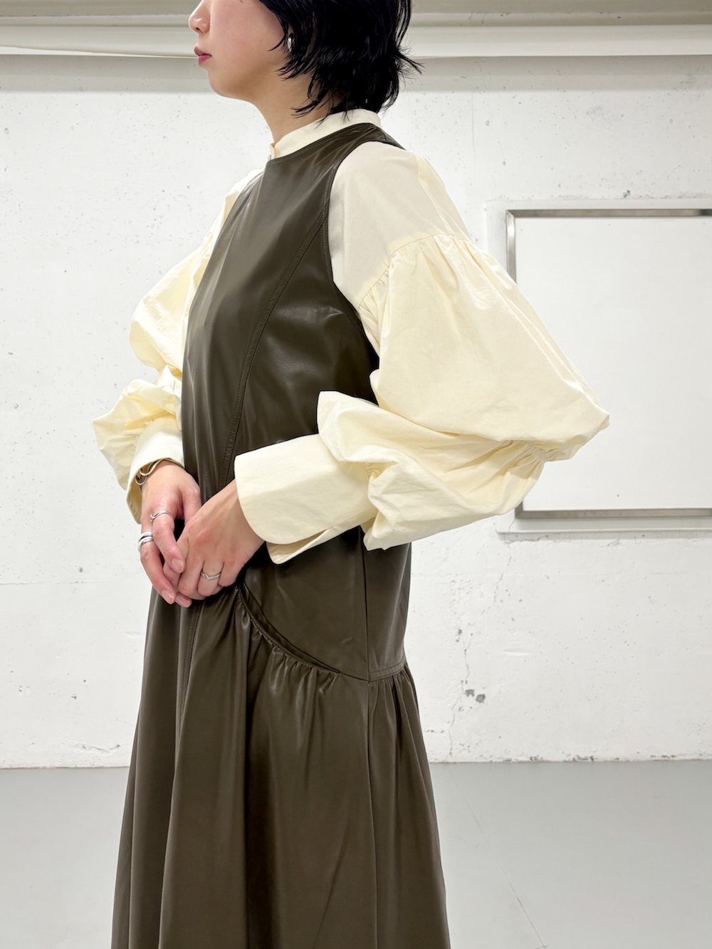 ホワイト系のシャツ/ブラウス、ブラウン系のワンピース、ブラック系のブーツを着用したレディースの冬コーディネートの2枚目の写真