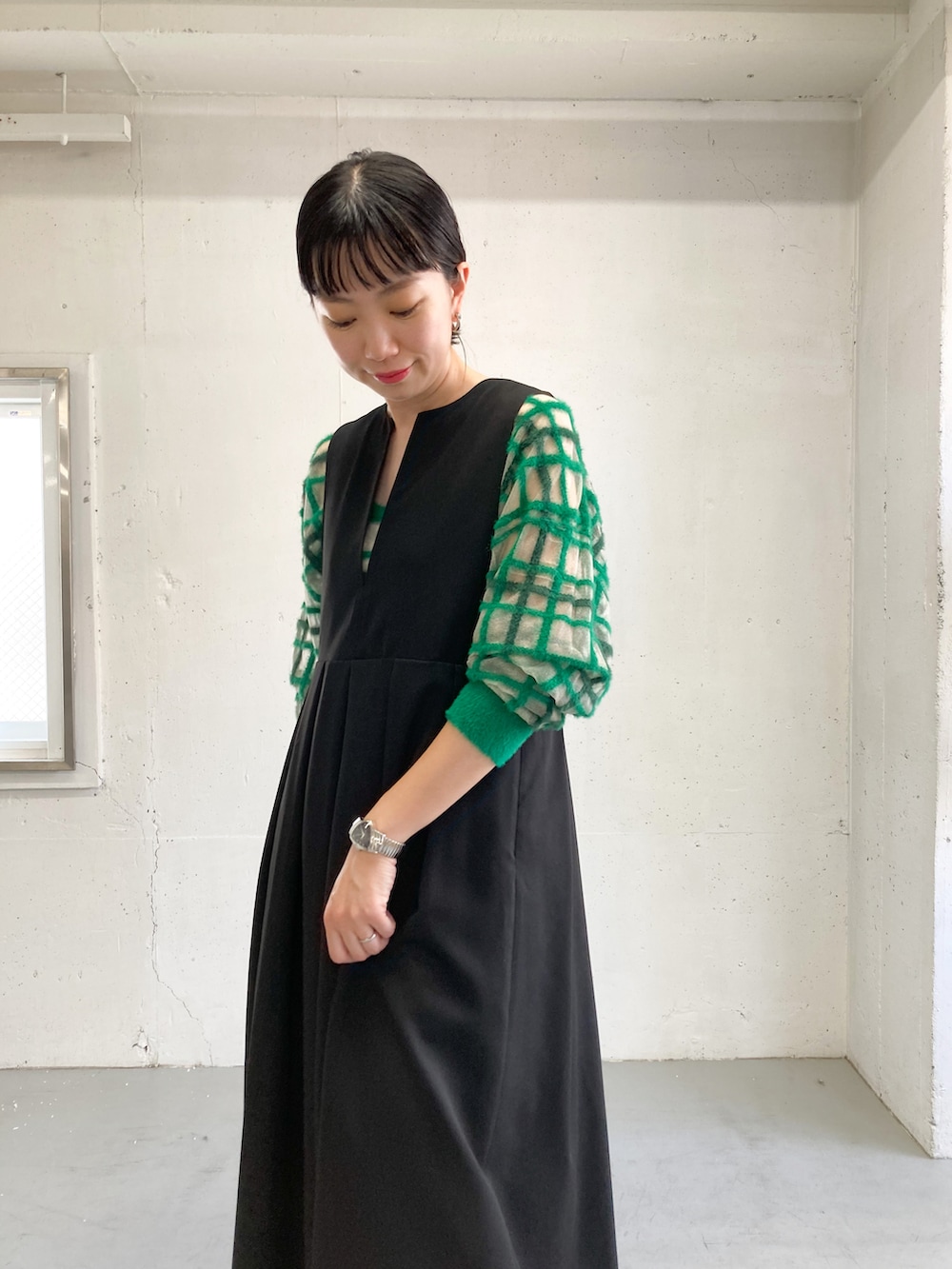ブラック系のワンピース、グリーン系のニット/セーター、ブラック系のブーツを着用したレディースの夏コーディネートの4枚目の写真