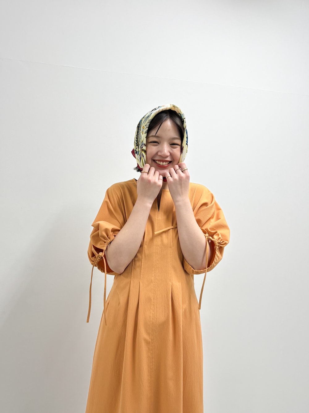 ベージュ系のその他シューズ、オレンジ系のワンピース、レッド系のバンダナ/スカーフを着用したレディースの春コーディネートの3枚目の写真