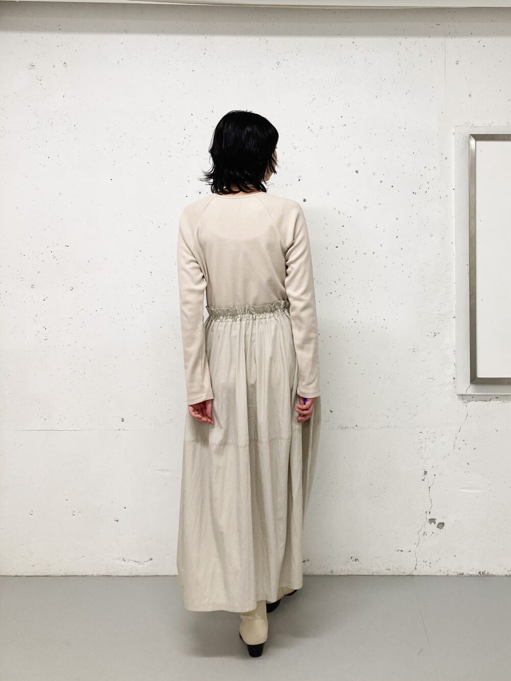 グレー系のワンピース、ブラウン系のテーラードジャケット、ホワイト系のブーツを着用したレディースの秋コーディネートの3枚目の写真