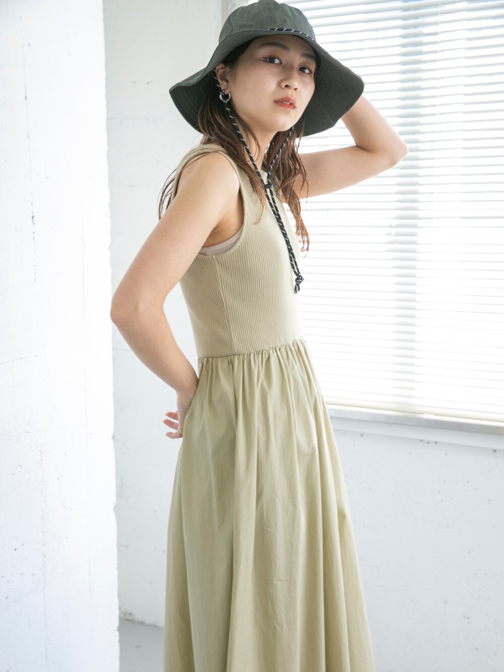 ベージュ系のワンピース、ブラック系のサンダル、グレー系のハットを着用したレディースの夏コーディネートの3枚目の写真