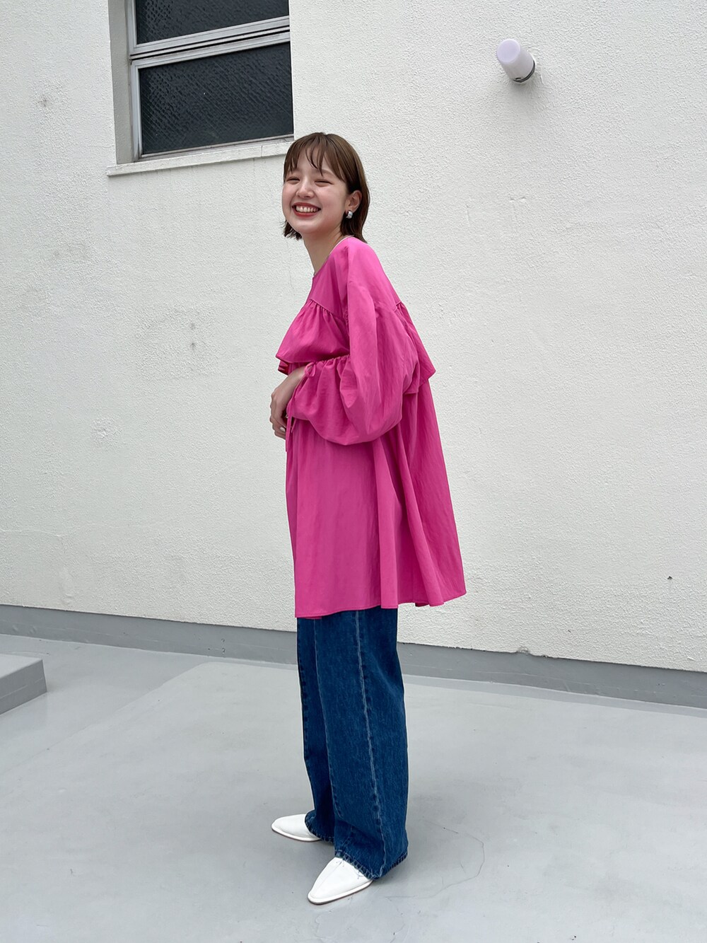 ブルー系のデニムパンツ、ピンク系のワンピース、ホワイト系のその他シューズを着用したレディースの春コーディネートの3枚目の写真