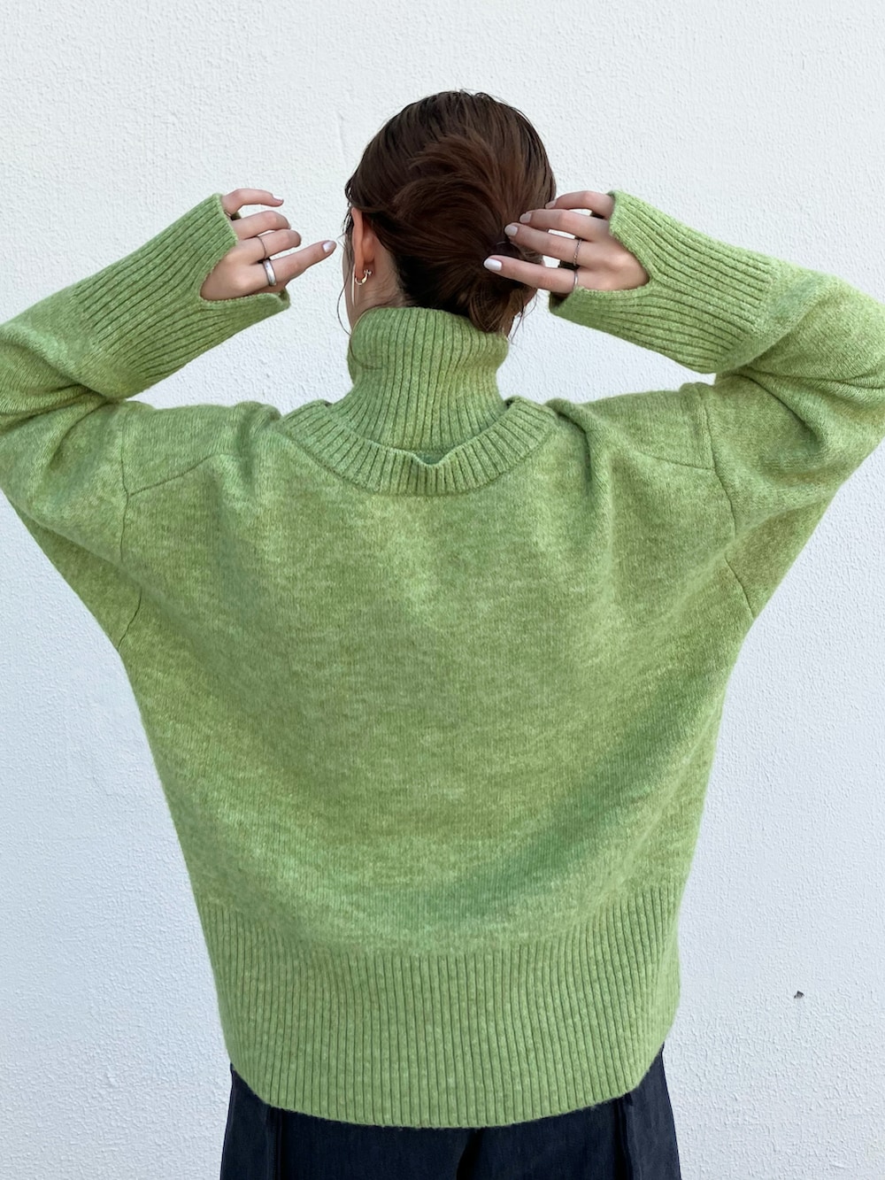 グリーン系のニット/セーター、グレー系のその他パンツ、ブラック系のブーツを着用したレディースの秋コーディネートの4枚目の写真