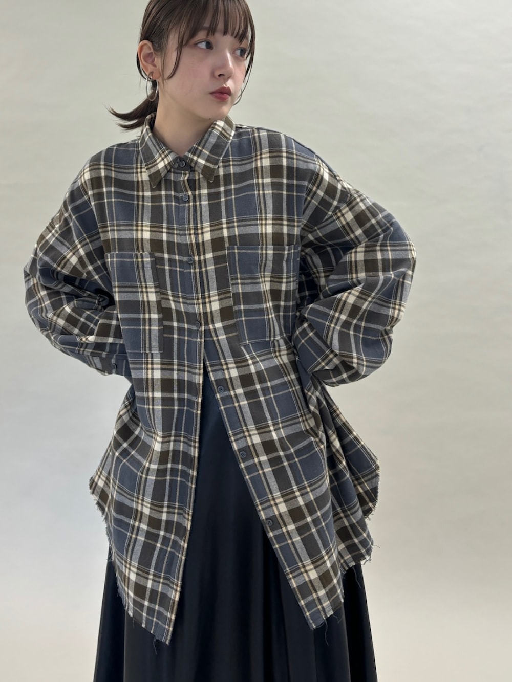 グレー系のシャツ/ブラウス、ブラック系のスカート、ブラック系のブーツを着用したレディースの秋コーディネートの2枚目の写真