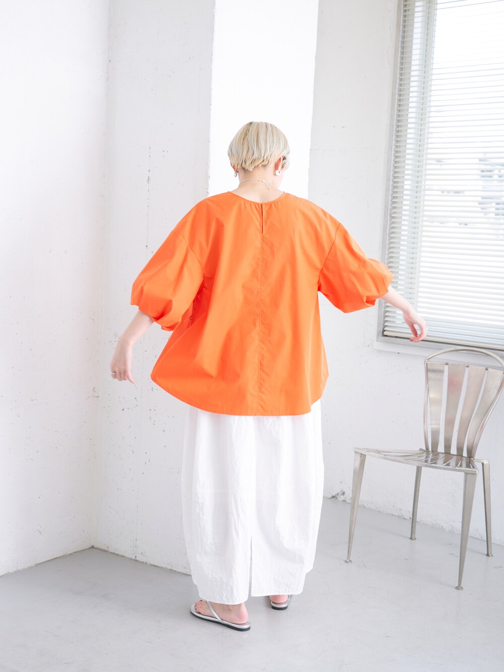 オレンジ系のシャツ/ブラウス、ホワイト系のスカートを着用したレディースの夏コーディネートの2枚目の写真