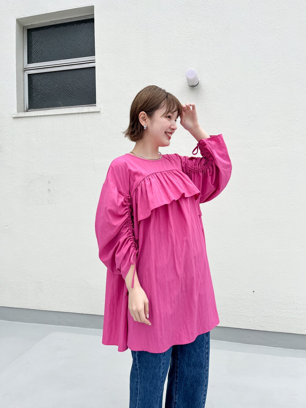 ブルー系のデニムパンツ、ピンク系のワンピース、ホワイト系のその他シューズを着用したレディースの春コーディネートの4枚目の写真