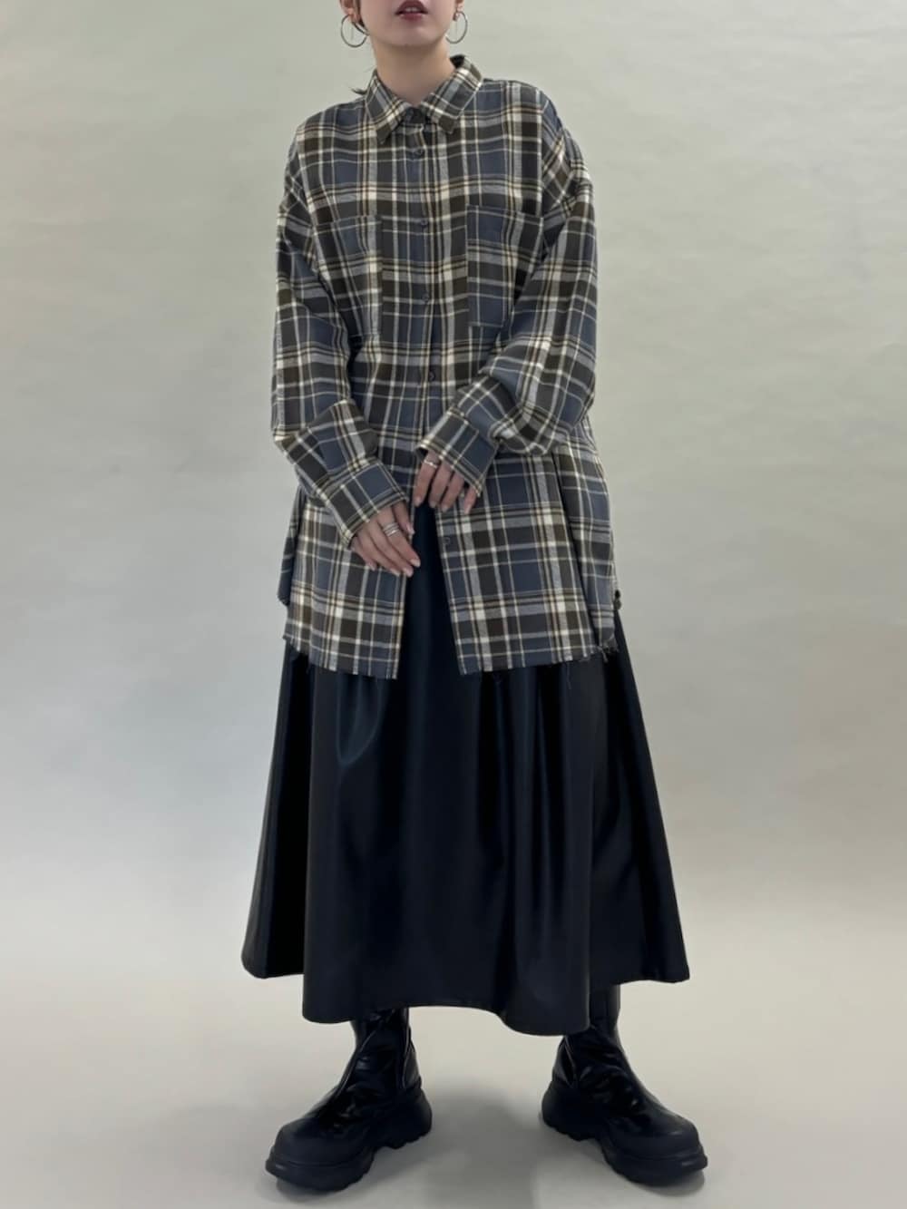 グレー系のシャツ/ブラウス、ブラック系のスカート、ブラック系のブーツを着用したレディースの秋コーディネートの3枚目の写真