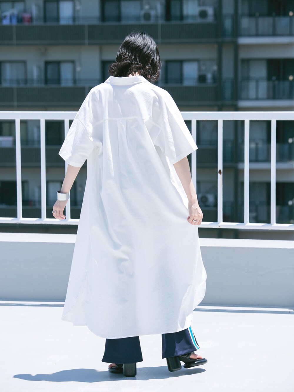 ホワイト系のワンピース、ブルー系のその他パンツ、ブラック系のサンダルを着用したレディースの夏コーディネートの2枚目の写真