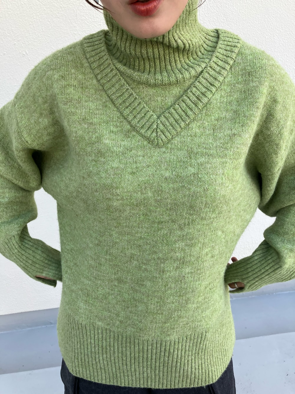 グリーン系のニット/セーター、グレー系のその他パンツ、ブラック系のブーツを着用したレディースの秋コーディネートの2枚目の写真