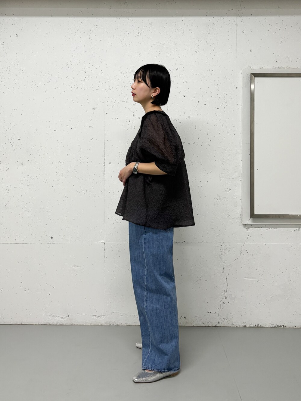 グレー系のシャツ/ブラウス、ブルー系のデニムパンツ、シルバー系のパンプスを着用したレディースの春コーディネートの2枚目の写真