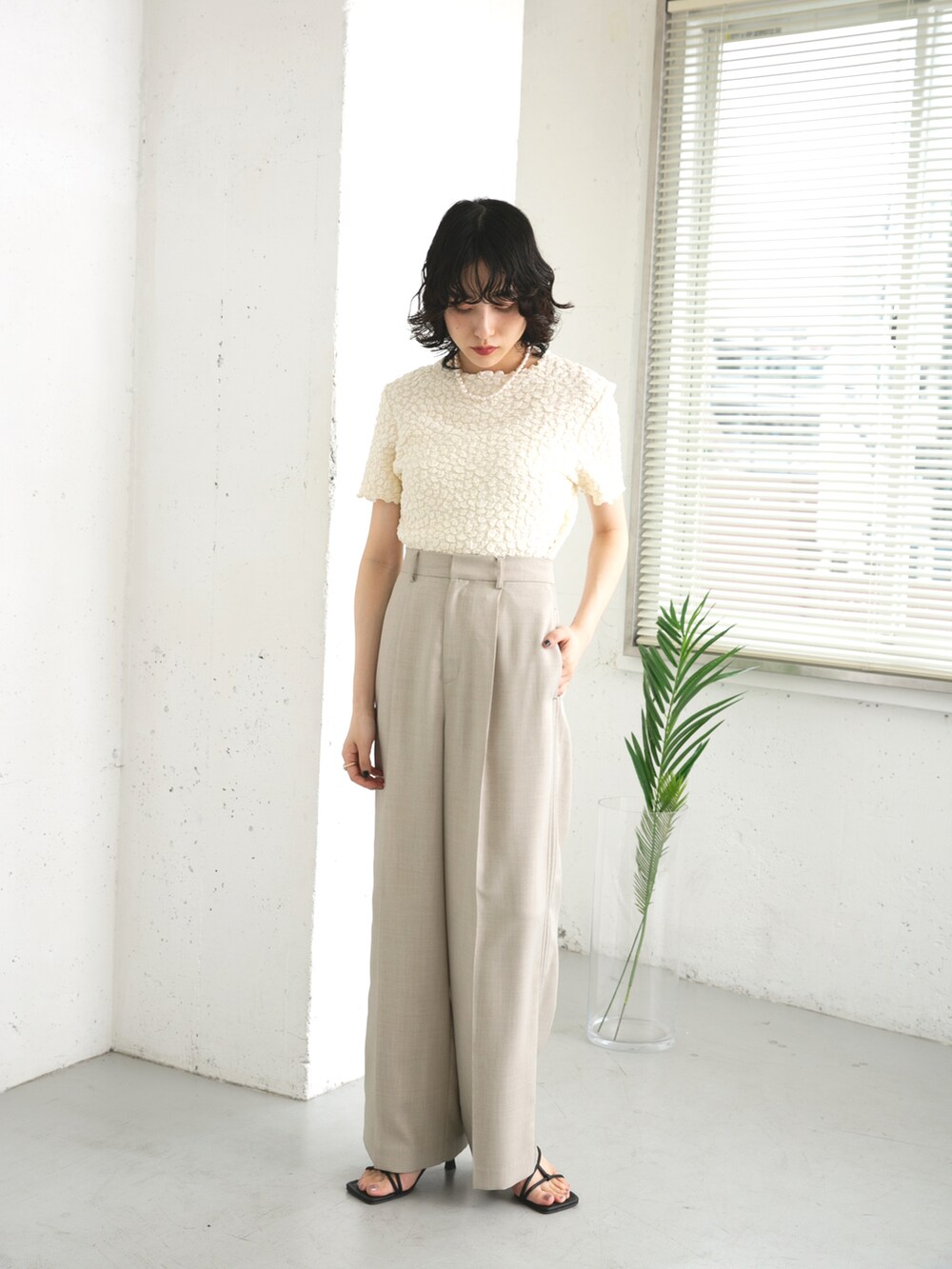 ブラック系のサンダル、ホワイト系のTシャツ/カットソー、グレー系のその他パンツを着用したレディースの夏コーディネートの2枚目の写真