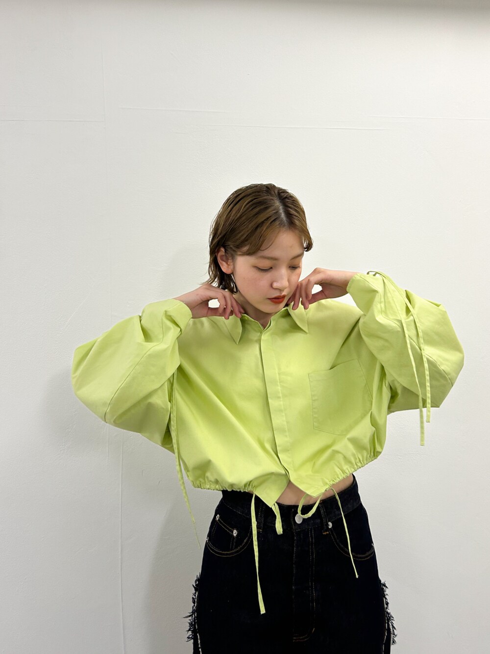 グリーン系のシャツ/ブラウス、ホワイト系のその他シューズ、ブルー系のデニムパンツを着用したレディースの春コーディネートの3枚目の写真