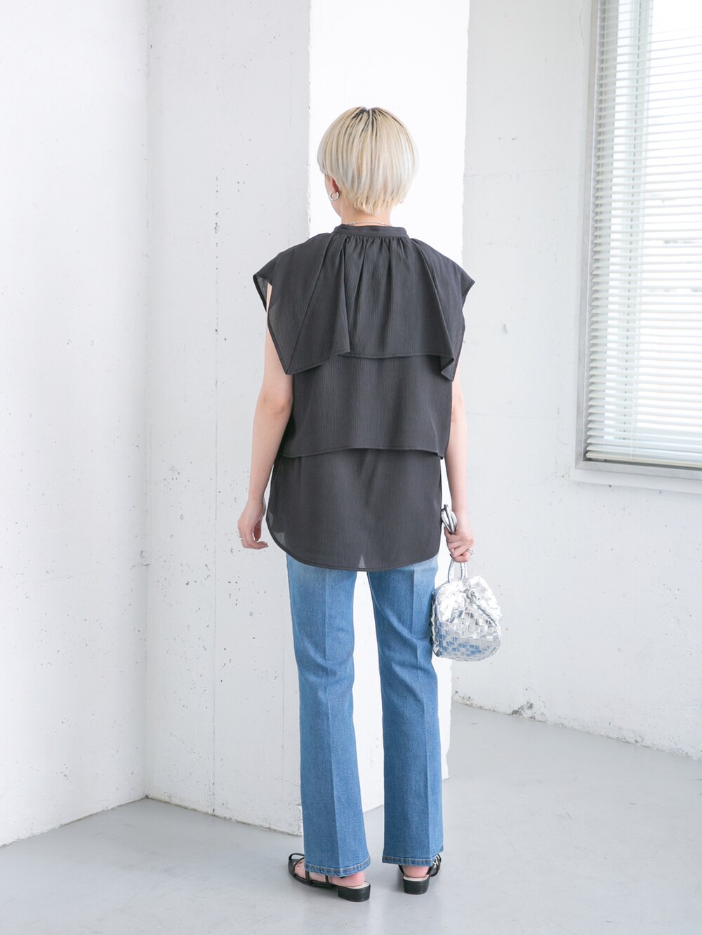 ブラック系のシャツ/ブラウス、ブルー系のデニムパンツ、シルバー系のショルダーバッグを着用したレディースの夏コーディネートの3枚目の写真