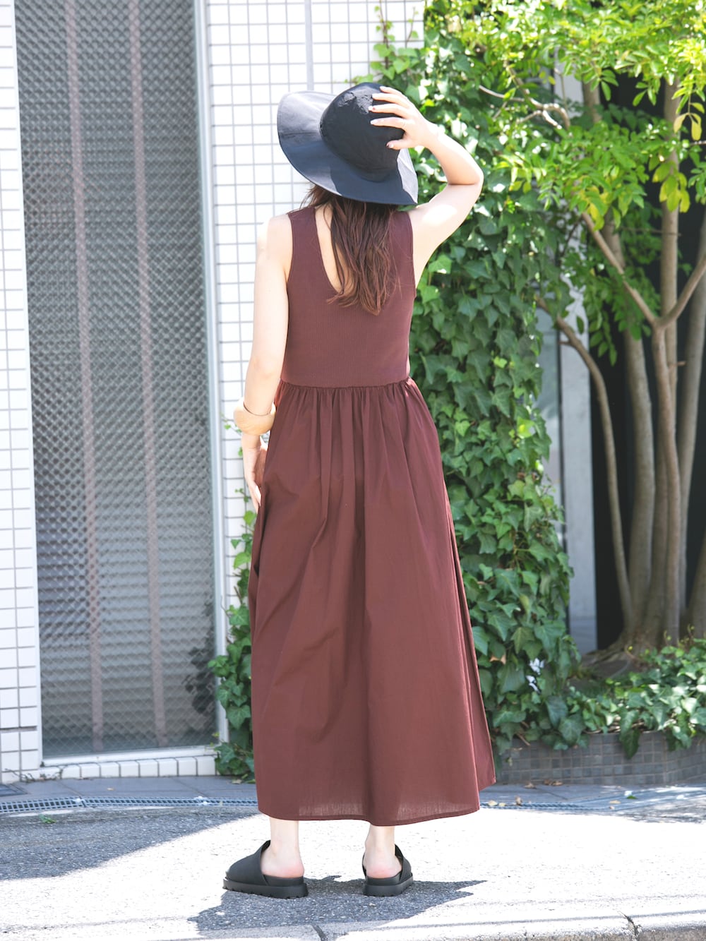 ブラック系のサンダル、ブラウン系のワンピース、ブラック系のハットを着用したレディースの夏コーディネートの2枚目の写真