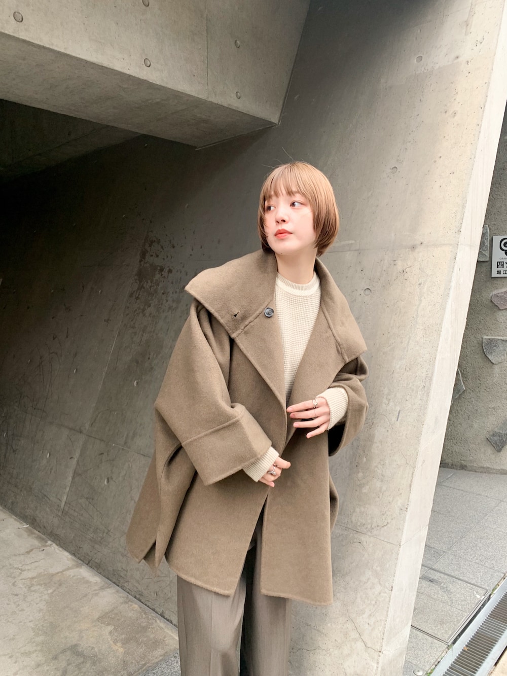 ブラウン系のその他アウター、ホワイト系のニット/セーター、グリーン系のサロペット/オーバーオールを着用したレディースの冬コーディネートの2枚目の写真