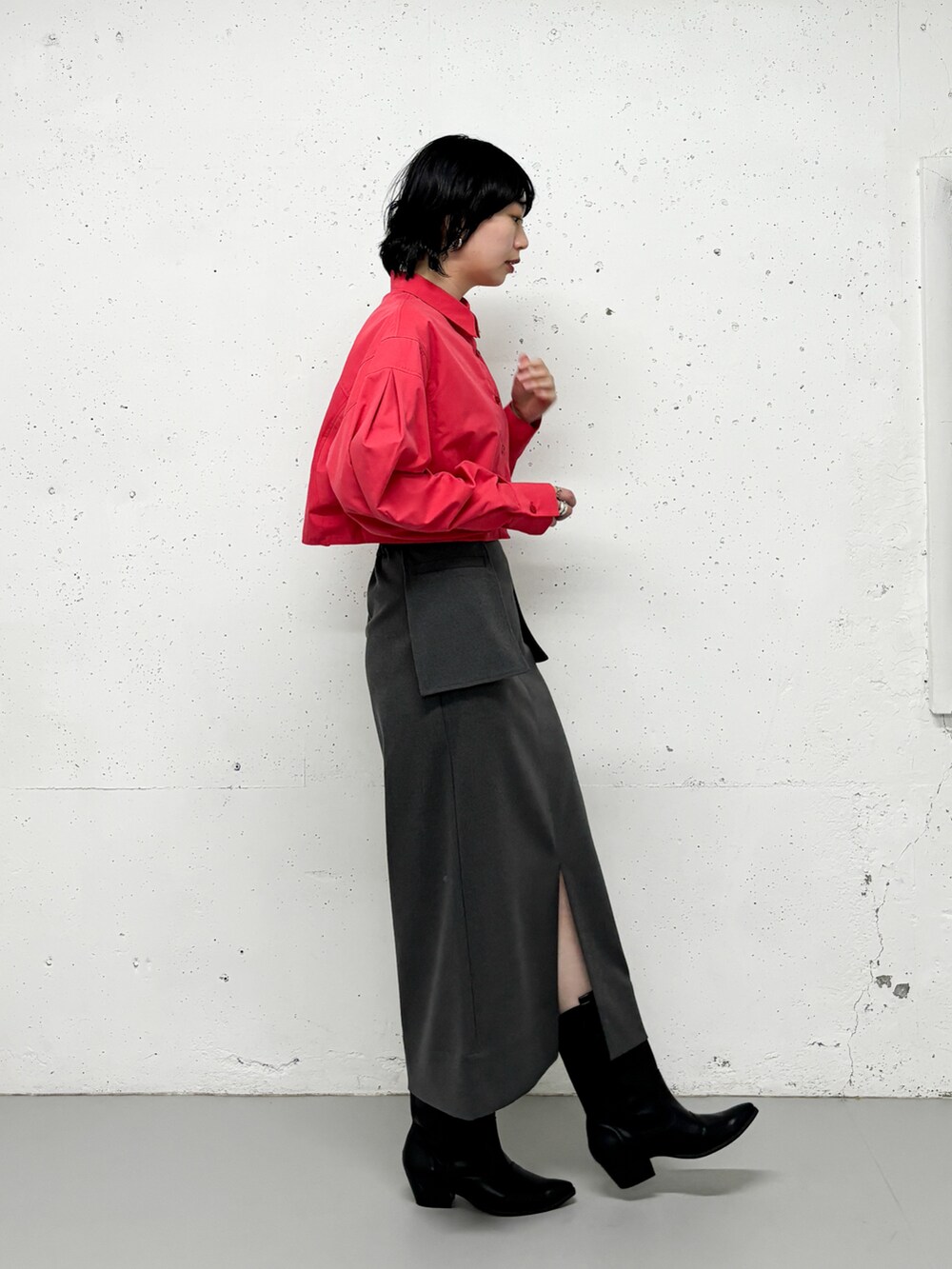 ピンク系のシャツ/ブラウス、グレー系のスカート、ブラック系のブーツを着用したレディースの冬コーディネートの2枚目の写真