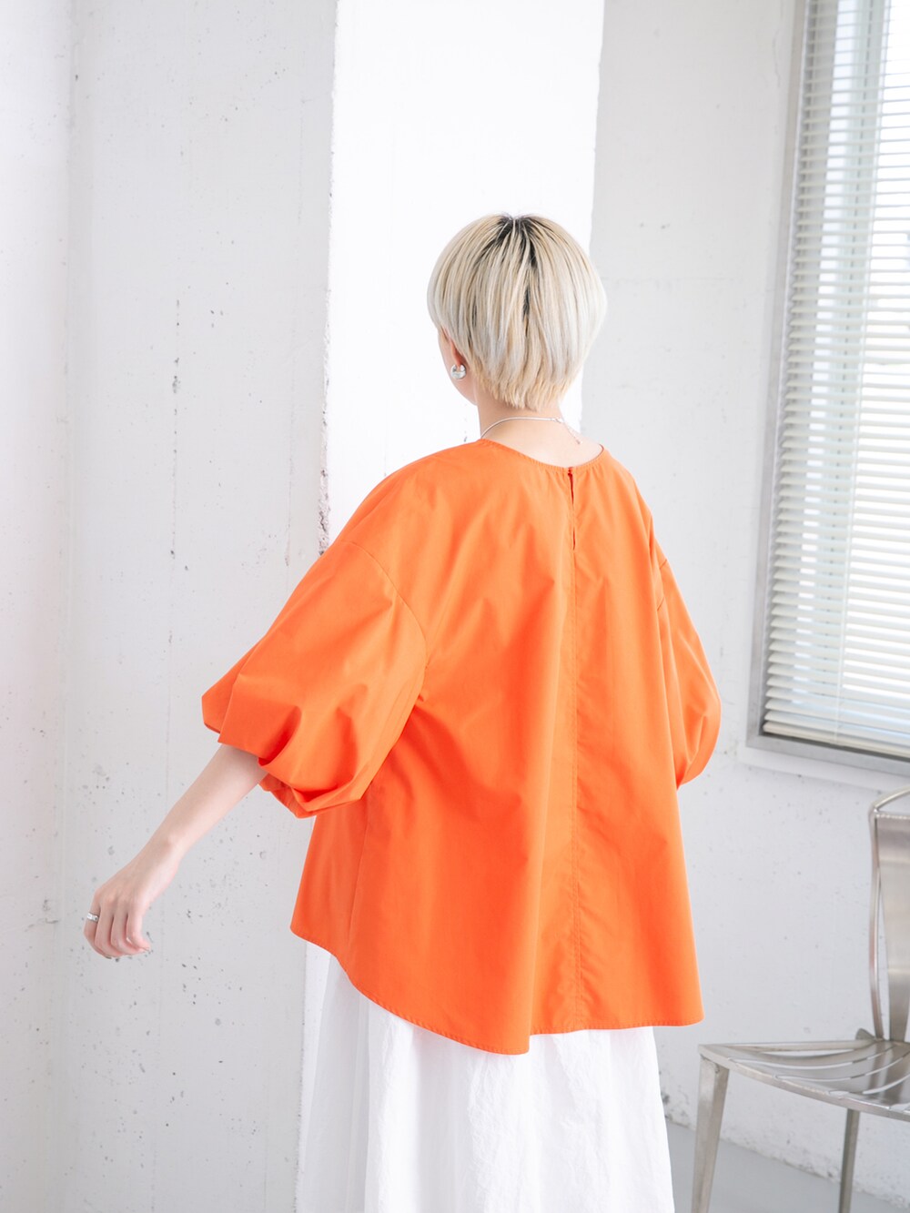 オレンジ系のシャツ/ブラウス、ホワイト系のスカートを着用したレディースの夏コーディネートの4枚目の写真