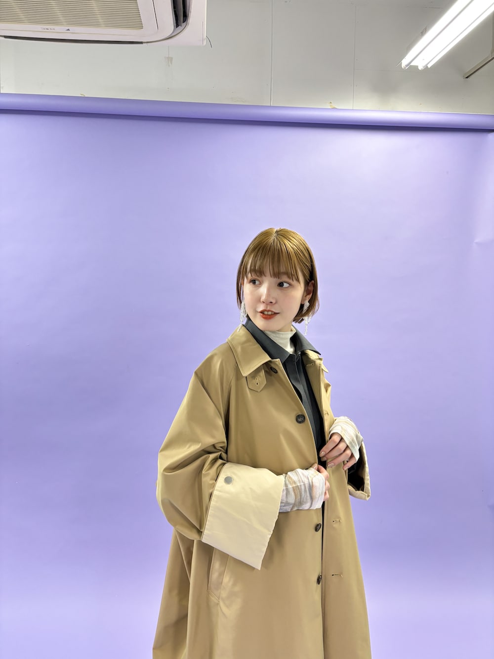 グレー系のステンカラーコートを着用したレディースの冬コーディネートの2枚目の写真