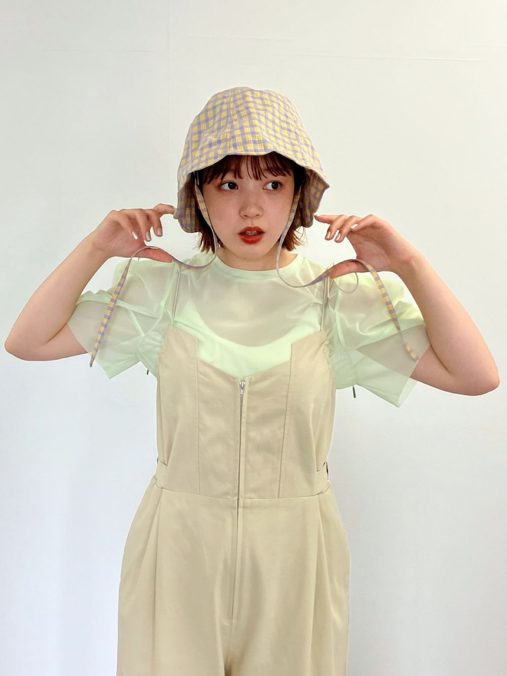 ベージュ系のサロペット/オーバーオール、グリーン系のTシャツ/カットソーを着用したレディースの春コーディネートの2枚目の写真