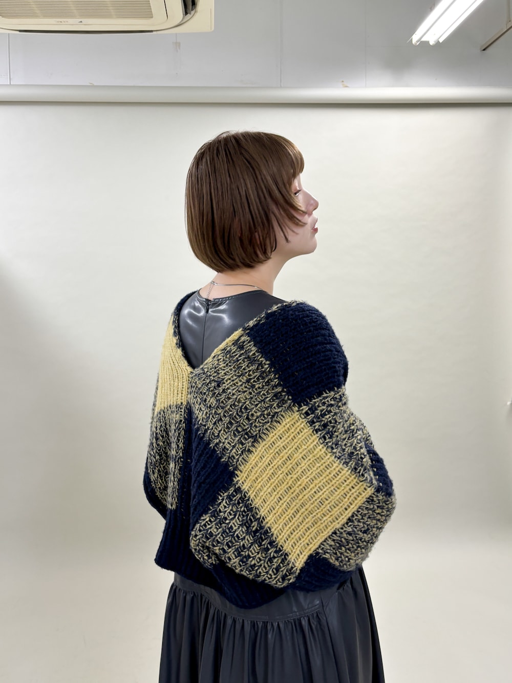 ブルー系のカーディガン/ボレロ、グレー系のワンピース、ブラック系のブーツを着用したレディースの冬コーディネートの4枚目の写真