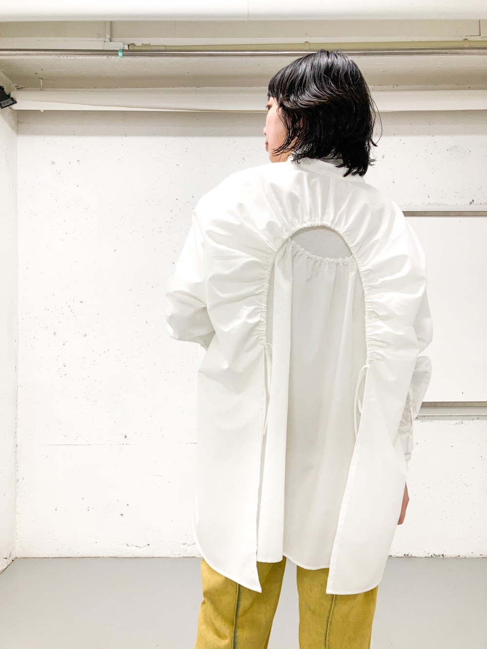 ホワイト系のシャツ/ブラウス、ホワイト系のTシャツ/カットソー、オレンジ系のデニムパンツを着用したレディースの秋コーディネートの3枚目の写真