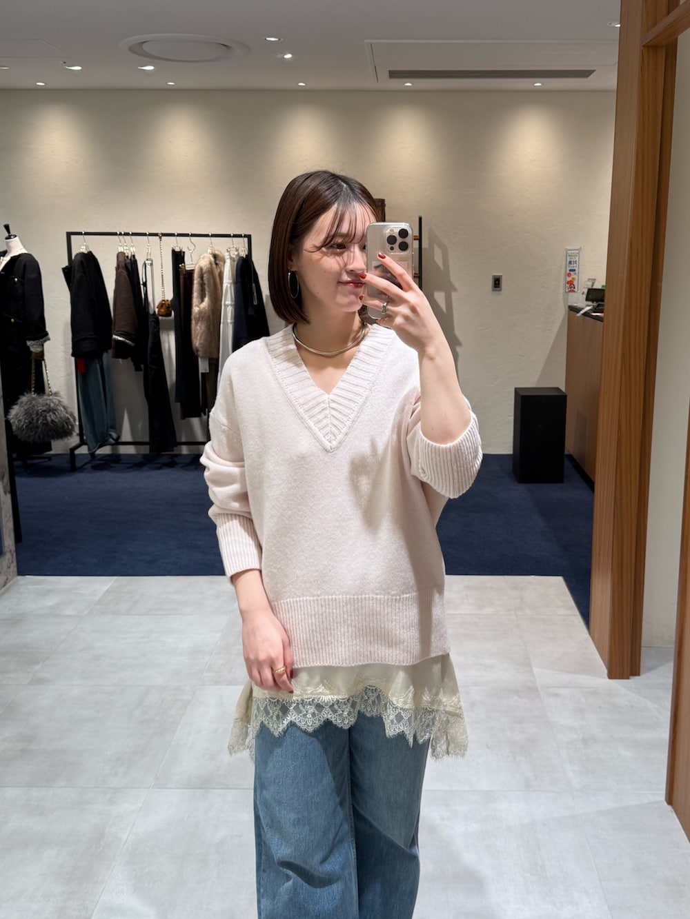 ピンク系のニット/セーター、ホワイト系のキャミソール、ブルー系のデニムパンツを着用したレディースの冬コーディネートの2枚目の写真