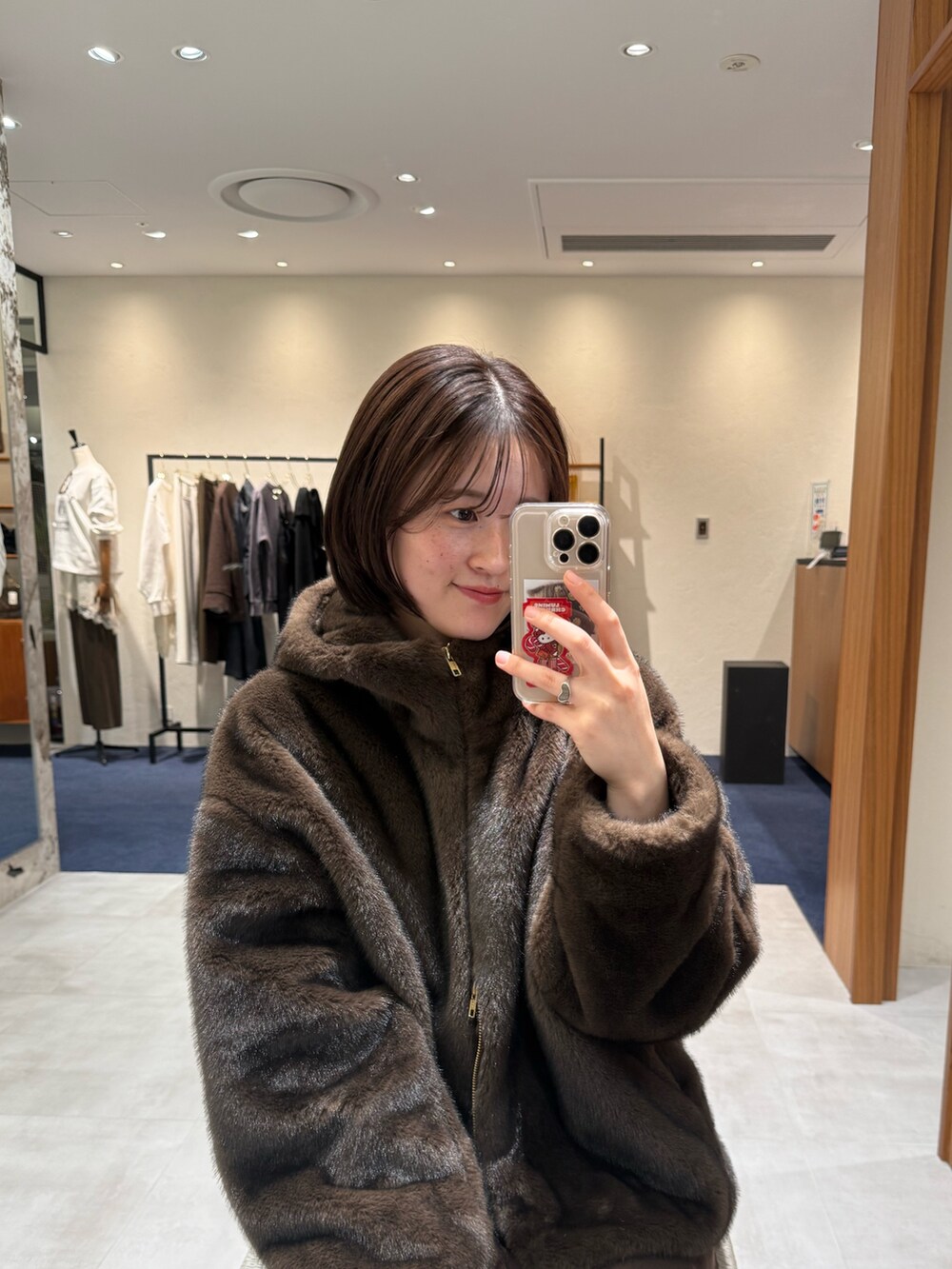 ホワイト系のニット/セーター、ブラウン系のブルゾン、ブラウン系のスカートを着用したレディースの冬コーディネートの3枚目の写真