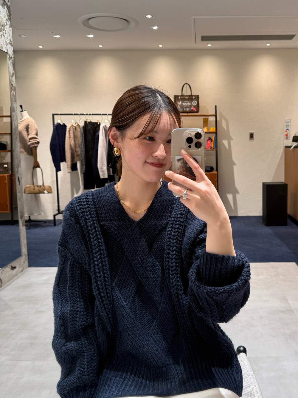 ブルー系のニット/セーター、ベージュ系のスカート、ブラック系のブーツを着用したレディースの冬コーディネートの2枚目の写真