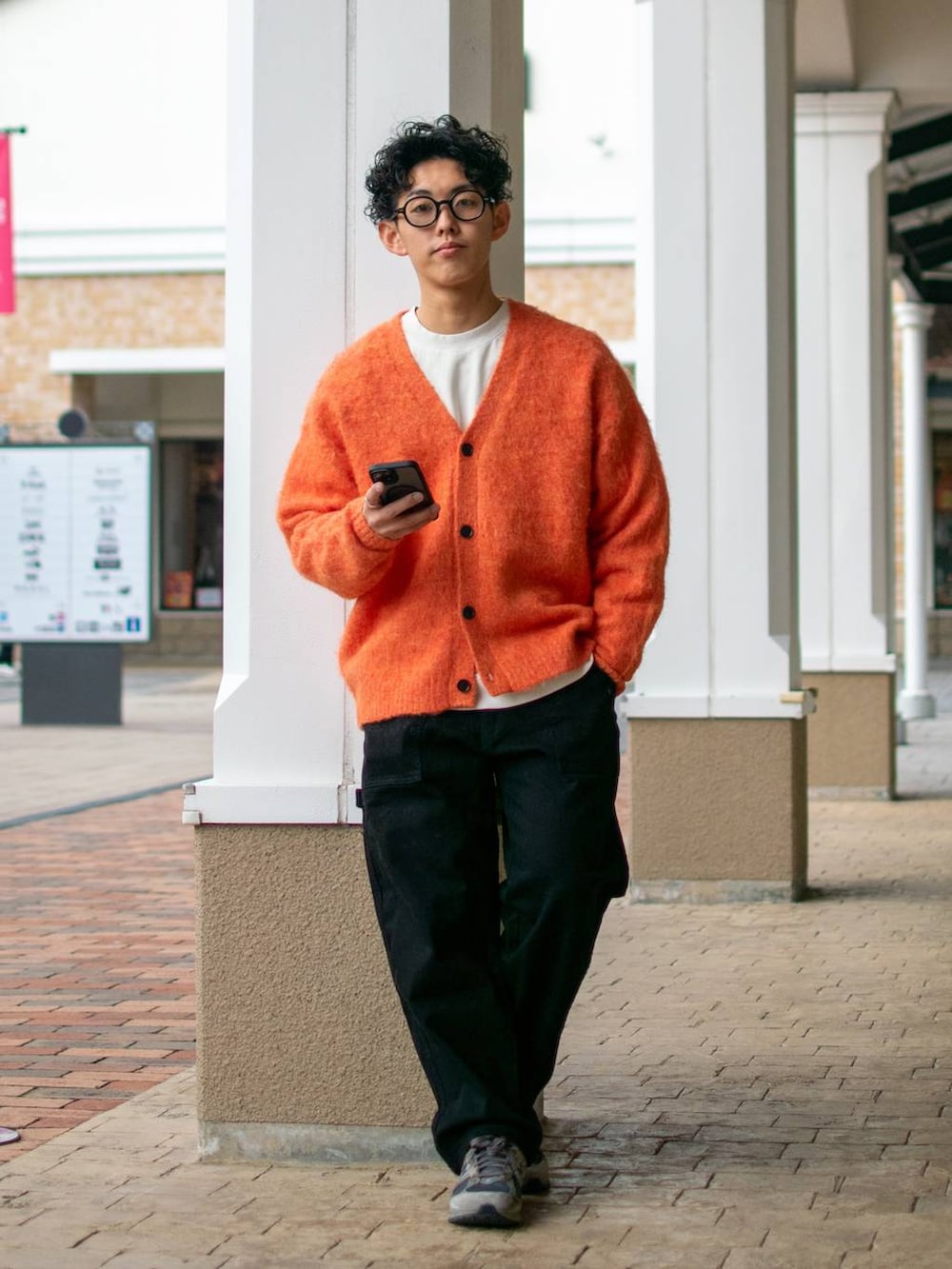 ブラック系のデニムパンツ、ホワイト系のスウェット、オレンジ系のカーディガン/ボレロを着用したメンズの冬コーディネートの3枚目の写真