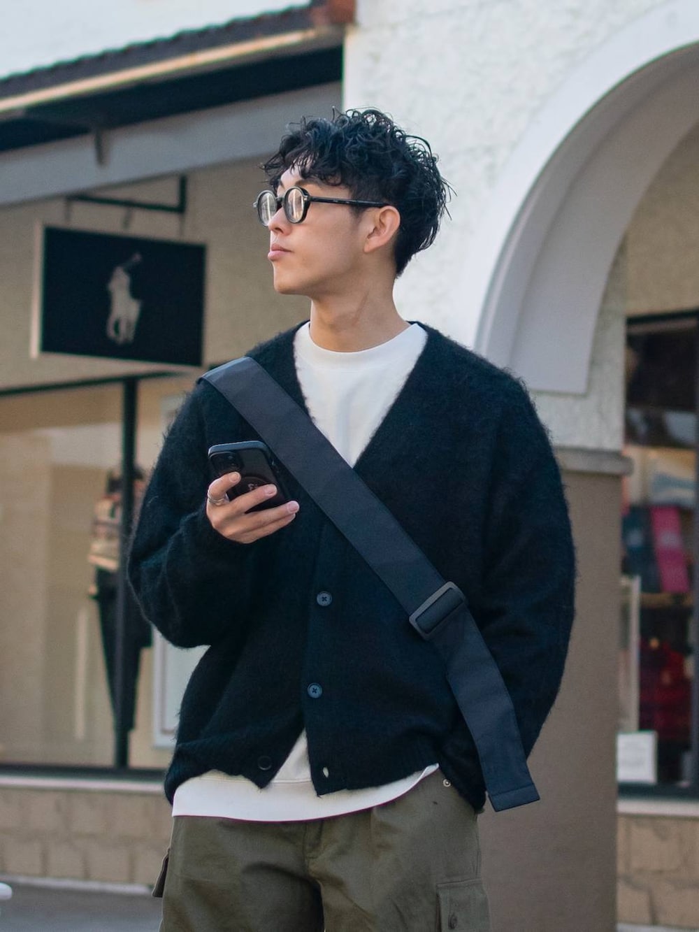 ブラック系のショルダーバッグ、グリーン系のカーゴパンツ、ホワイト系のスウェットを着用したメンズの冬コーディネートの5枚目の写真