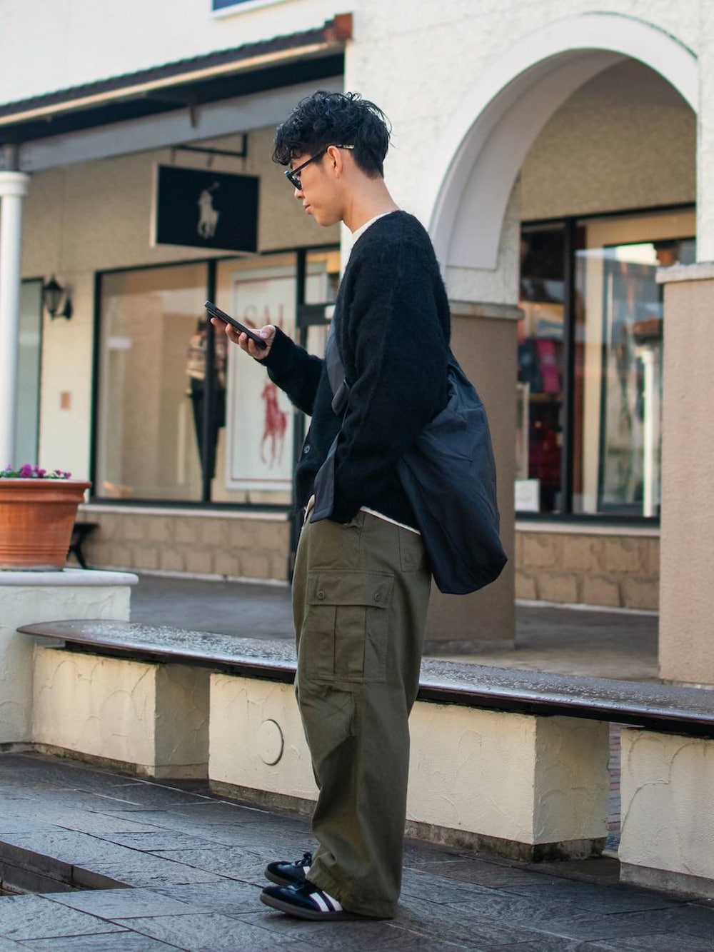 ブラック系のショルダーバッグ、グリーン系のカーゴパンツ、ホワイト系のスウェットを着用したメンズの冬コーディネートの4枚目の写真